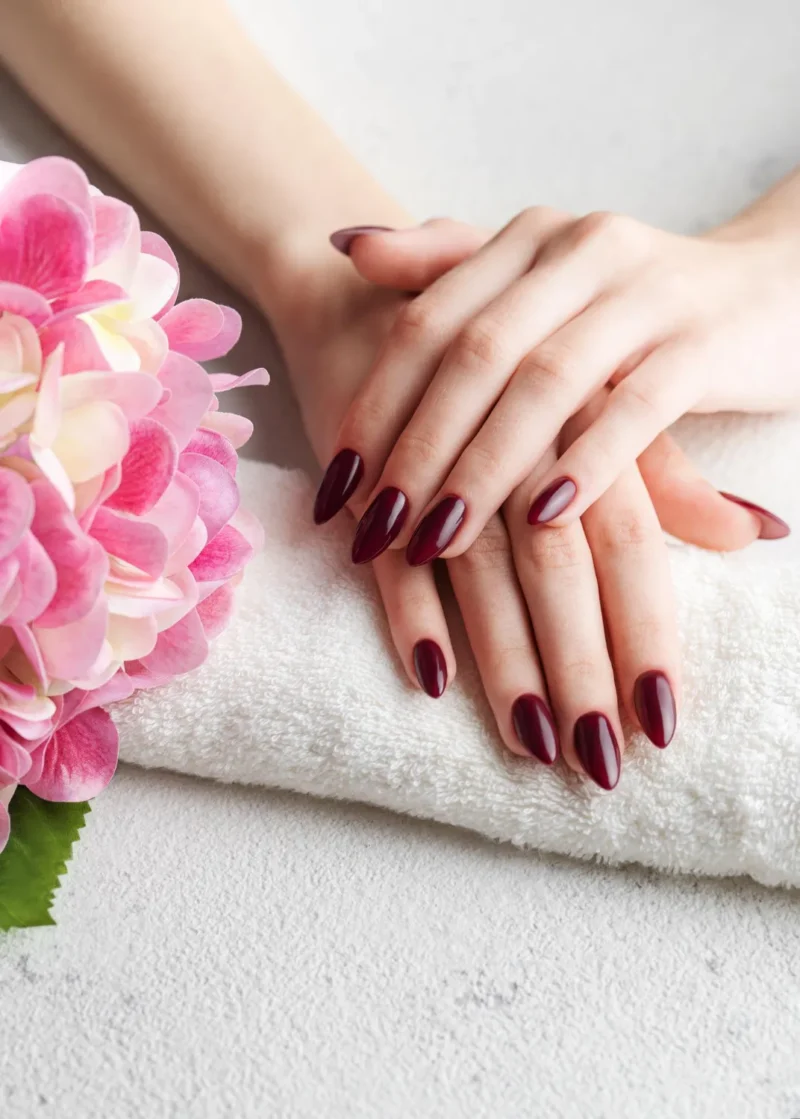 hands young woman with dark red manicure nails